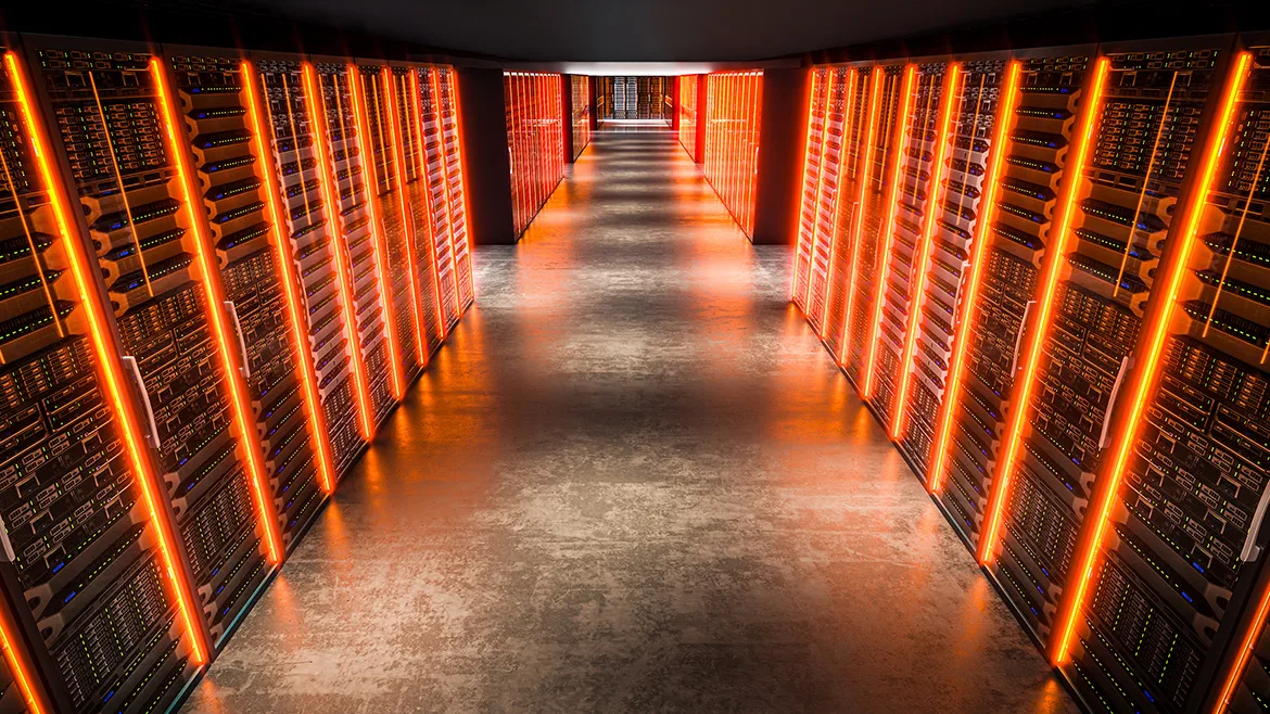 Servers with orange lights illuminating the corridor in a data center
