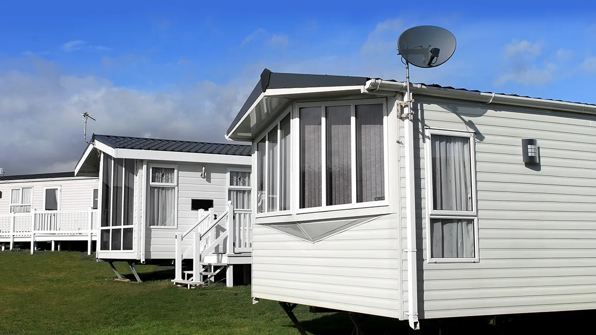 Scenic view of a manufactured home community in summer with blue sky and cloudscape background