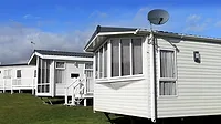 Scenic view of a manufactured home community in summer with blue sky and cloudscape background