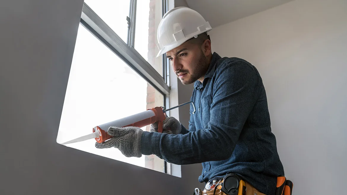 GI-1300212981-1170x658.jpg Latin American building contractor installing a window and applying sealant