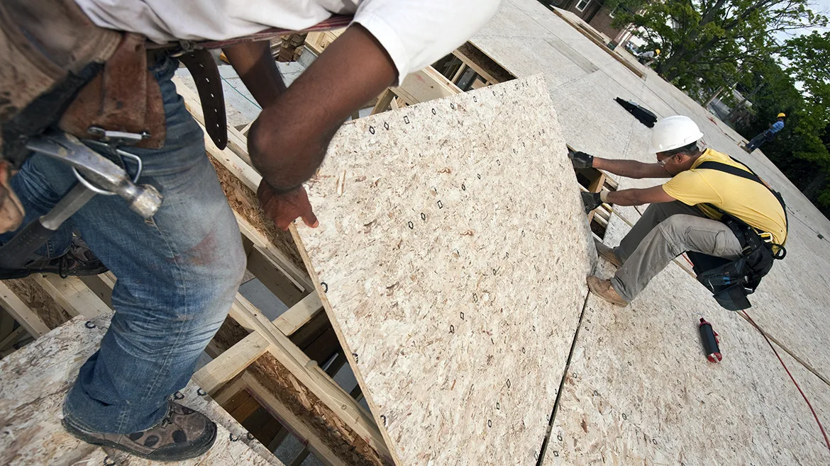 Carpenters putting a particle board in place