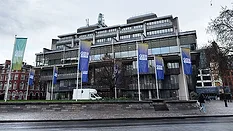 Queen Elizabeth II Centre Queen Elizabeth II Centre exterior with banners and flags in central London, UK under overcast sky