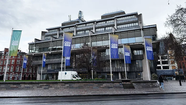  Queen Elizabeth II Centre exterior with banners and flags in central London, UK under overcast sky