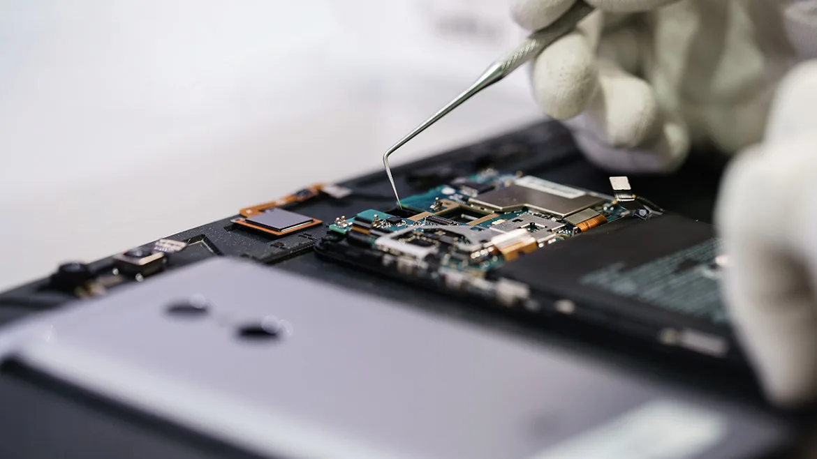 Close-up hands of a service worker repairing modern smartphone