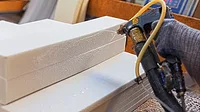 1-GI-2280049592-1170x658.jpg Spraying adhesive glue onto foam pieces in manufacturing factory