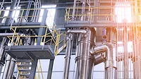 A complex network of pipes and vessels in a modern chemical processing facility