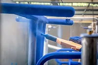 TEGO Powder Aid small for web.jpg Image of blue powder coating being applied to metal