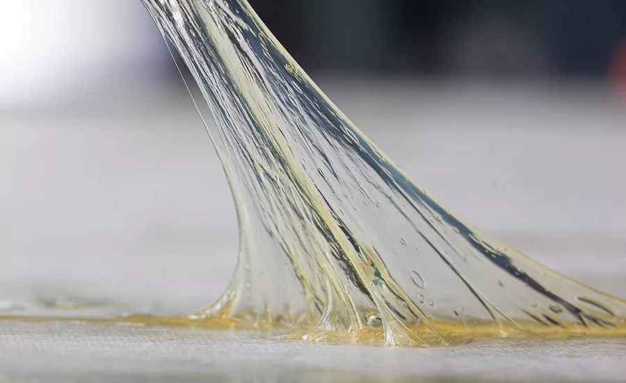 Image of the Conagen debondable adhesive being pulled up from a flat surface