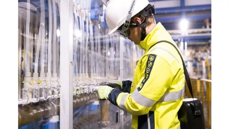 image of man in high visibility gear and hard hat in a plant