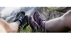 image of two hiker's feet dangling atop a mountain