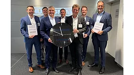 Seven men in blue suits standing together and holding a clock
