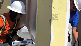 Image of two men applying sealant to window frame