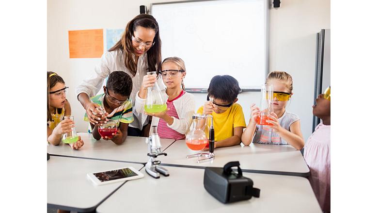 Image of a teacher working on a science project with children.