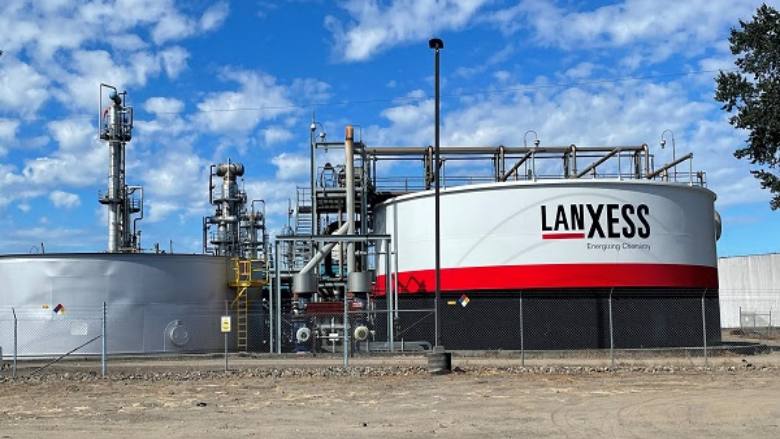 Picture of several large storage tanks with the LANXESS logo painted on the exterior. 
