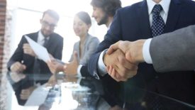 background image of handshake of business partners in conference room