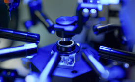 Image of an blue automotive camera lens being assembled