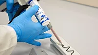 SCIGRIP SG300 structural adhesive from Intertronics Picture of a gloved hand dispensing adhesive on a metal plate