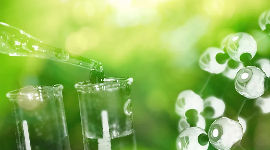 A close-up of a test tube with a green background