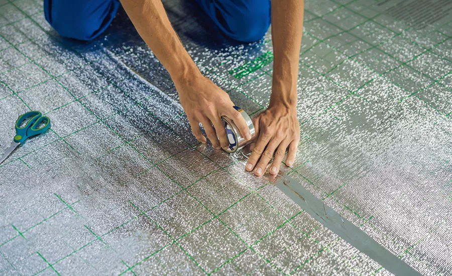 Picture of a man applying tape to a floor