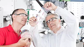Two people in a lab looking at a label