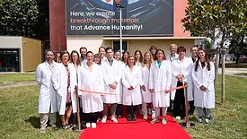 Picture of people standing on a red carpet in front of a new building