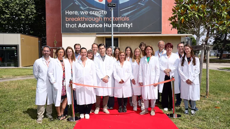 Picture of people standing on a red carpet in front of a new building