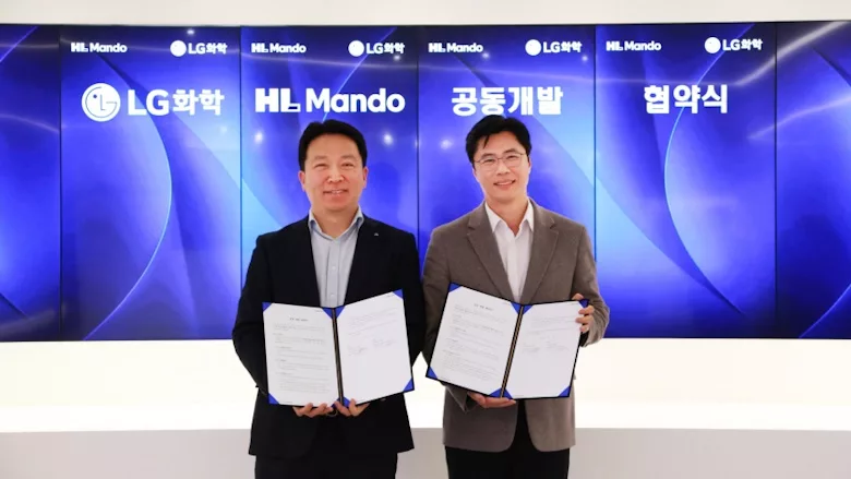 Picture of two men holding signed papers