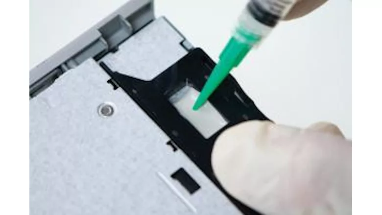 Picture of an adhesive being dispensed on an electrical part