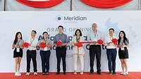 Ribbon cutting at Meridian Penang Application Development Center Picture of eight people standing in front of a ribbon