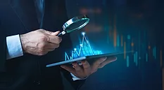 A person holding a tablet with a magnifying glass