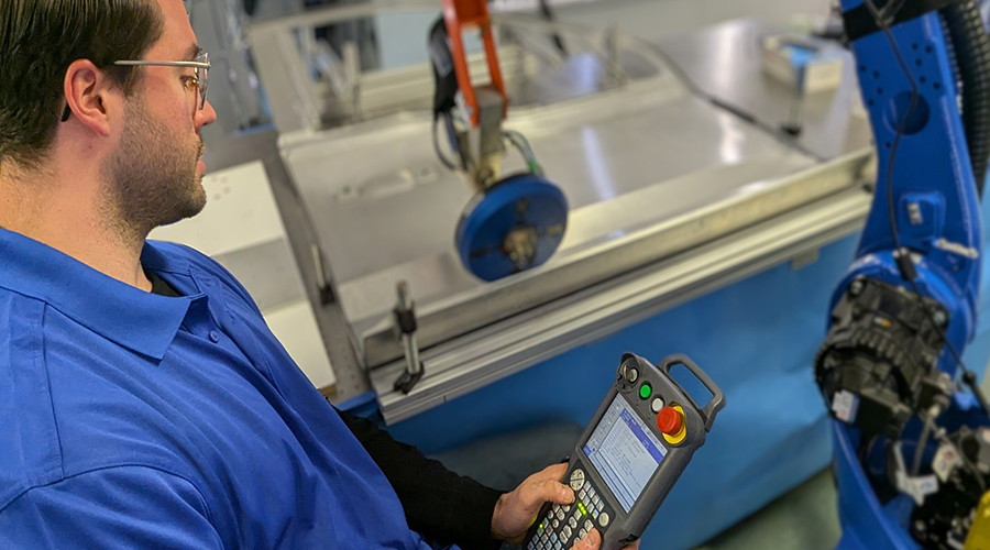 An applications engineer programs a Yaskawa robot with a 3D inspection system.