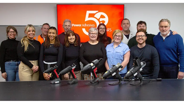 Picture of people standing at a table of glue guns