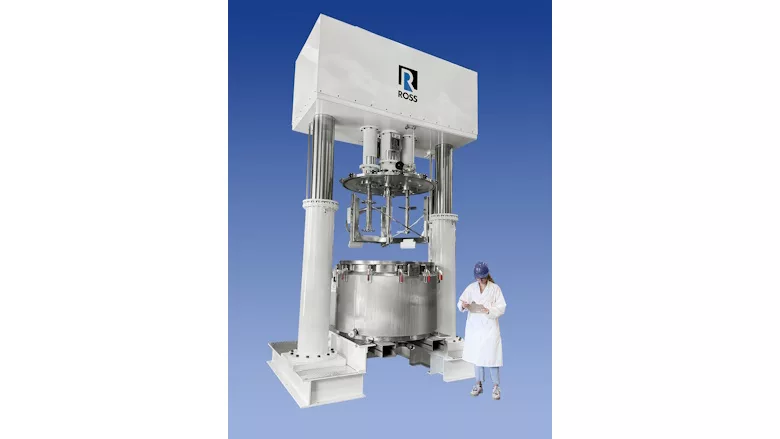 Picture of large mixer with man standing next to it