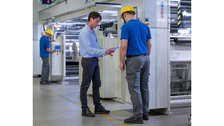 Picture of two men in hard hats at a manufacturing facility
