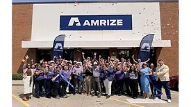 Picture of people standing in front of a building with Amrize written on the front