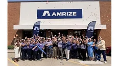Picture of people standing in front of a building with Amrize written on the front