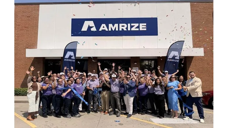 Picture of people standing in front of a building with Amrize written on the front