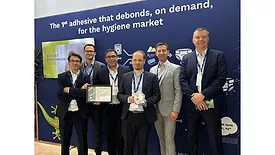 Picture of six men in suits with one man holding an award