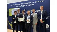 Picture of six men in suits with one man holding an award