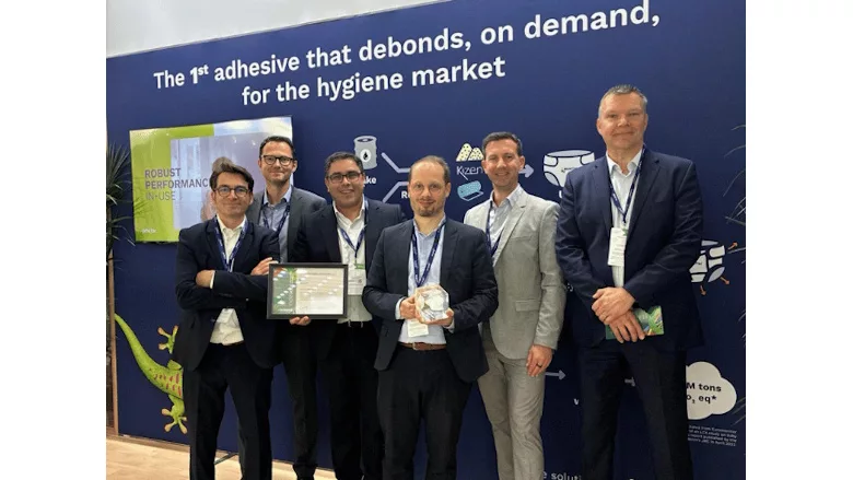 Picture of six men in suits with one man holding an award