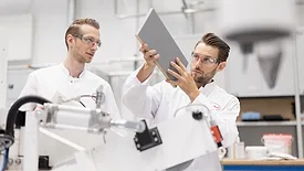Picture of two scientists holding up a piece of wood