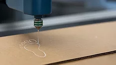 Picture of an adhesive being dispensed on cardboard