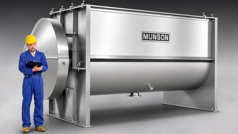 Man standing next to a very large stainless steel ribbon blender