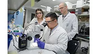 Picture of a scientist looking through a microscope