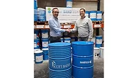 Scott Bader and Sandtech Picture of two men shaking hands in front of large blue drum containers