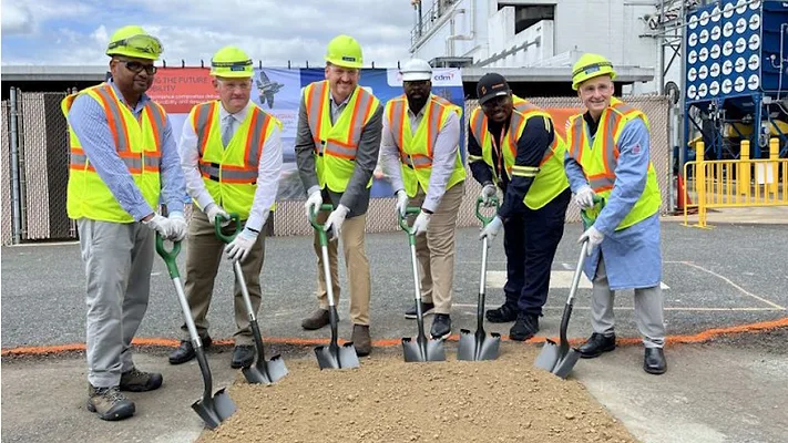 Picture of six men in safety vests and yellow hard hats with shovels