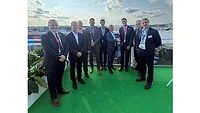 Syensqo representations sign agreement with Airbus Picture of nine men in suits standing on the rooftop of a building