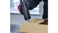 Tecbond 114 on cardboard Picture of a glue gun putting hot melt adhesive on cardboard