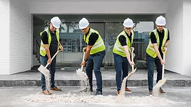 Picture of four men with shovels of dirt.