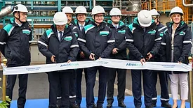 Picture of men in blue cutting a ribbon